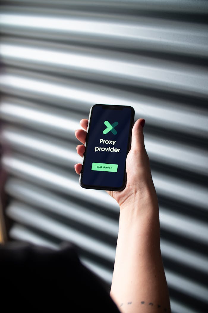 Close-up of a person holding a smartphone displaying a proxy provider app interface.